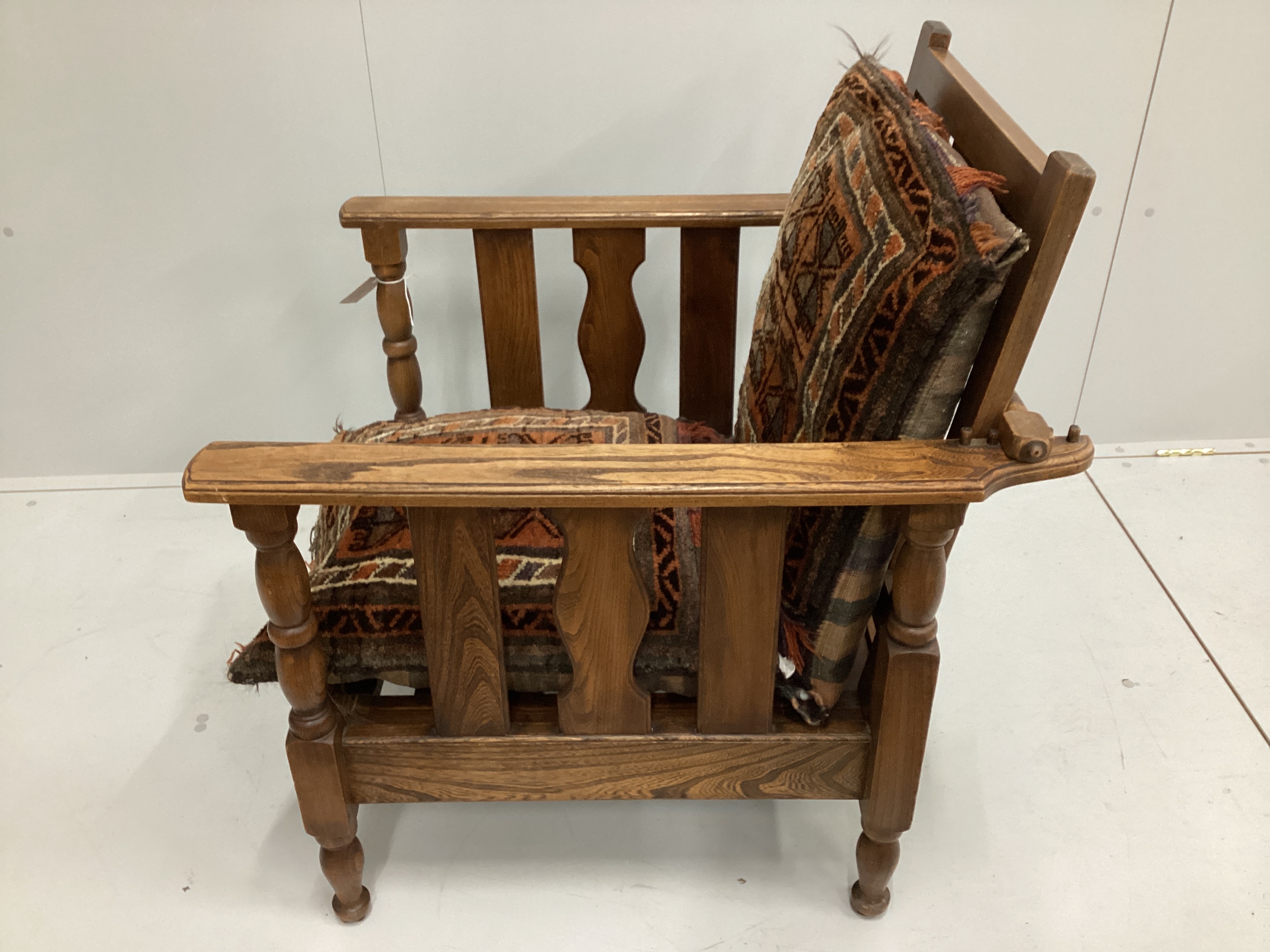 An early 20th oak reclining armchair with geometric saddlebag cushion seat and back width 70cm, depth 79cm, height 86cm.